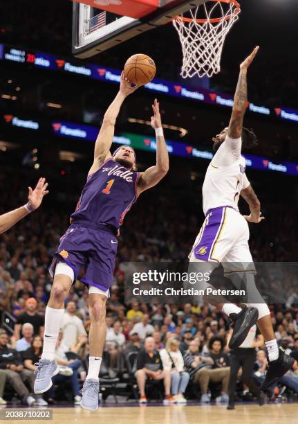 Devin Booker of the Phoenix Suns attempts a shot against D'Angelo Russell of the Los Angeles Lakers during the second half of the NBA game at...