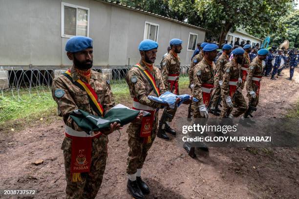 Pakistani peacekeepers hold the Pakistani and UN flags at the United Nations Organization Mission for the Stabilization of the Congo base during the...