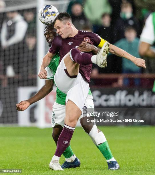 Hearts' Lawrence Shankland challenges for a header with Hibernian's Rocky Bushiri during a cinch Premiership match between Heart of Midlothian and...