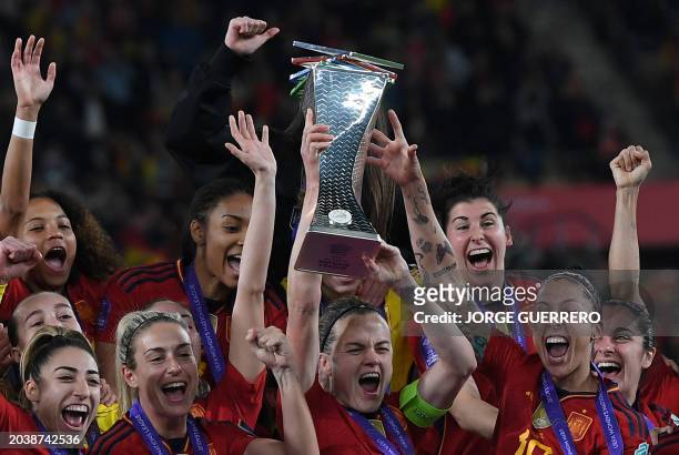 Spain's defender Irene Paredes lifts the trophy as her teammates celebrate winning during the podium ceremony after the UEFA Women's Nations League...