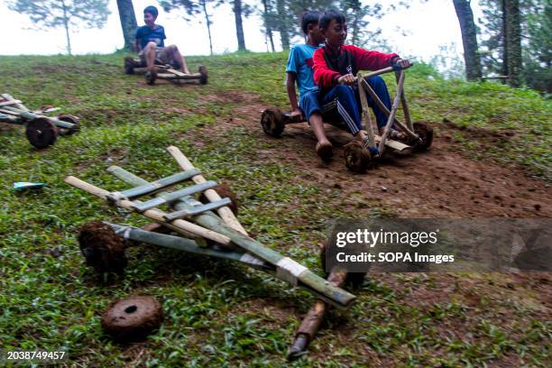Kids are joyfully riding a bamboo kart down a hill in Pasir Angling Village. The Pasir Angling village community is reintroducing traditional bamboo...
