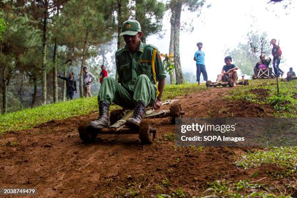 Resident rides a bamboo kart down a hill in Pasir Angling Village. The Pasir Angling village community is reintroducing traditional bamboo and wood...