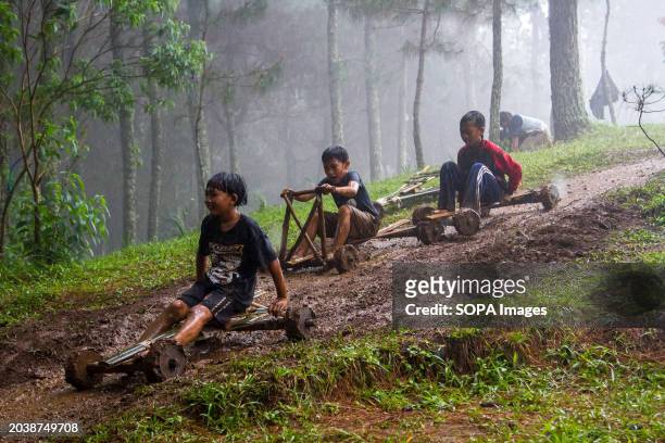 Kids are joyfully riding a bamboo kart down a hill in Pasir Angling Village. The Pasir Angling village community is reintroducing traditional bamboo...