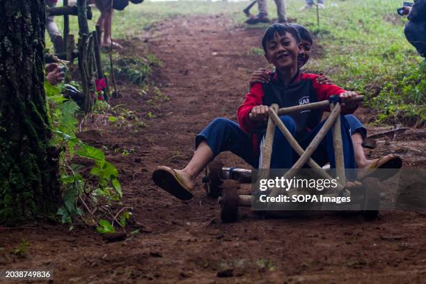 Kids are joyfully riding a bamboo kart down a hill in Pasir Angling Village. The Pasir Angling village community is reintroducing traditional bamboo...