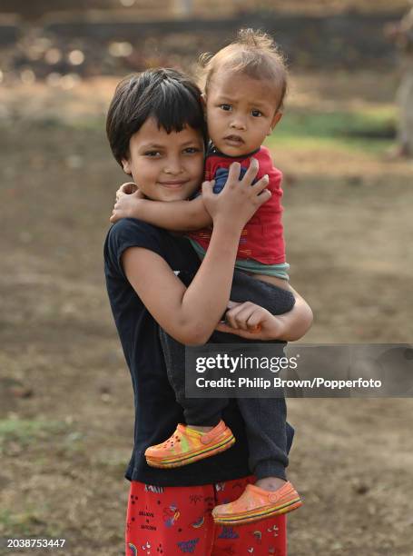 Girl looks after her brother in a field on February 28, 2024 in Ranchi, India.