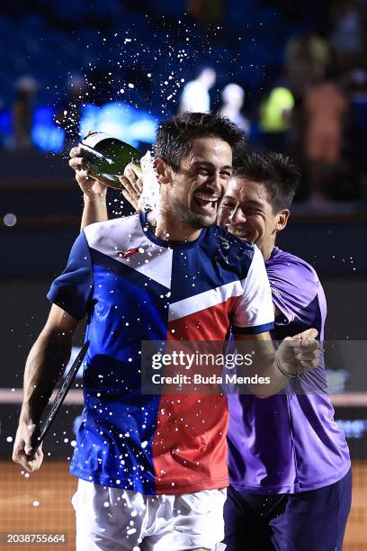 Sebastián Báez of Argentina pours champagne on Mariano Navone of Argentina after winning the final match against of Argentina of ATP 500 Rio Open...