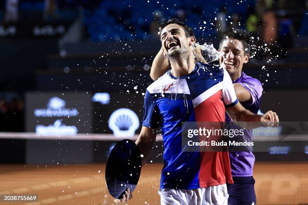 Sebastián Báez of Argentina pours champagne on Mariano Navone of Argentina after winning the final match against of Argentina of ATP 500 Rio Open...