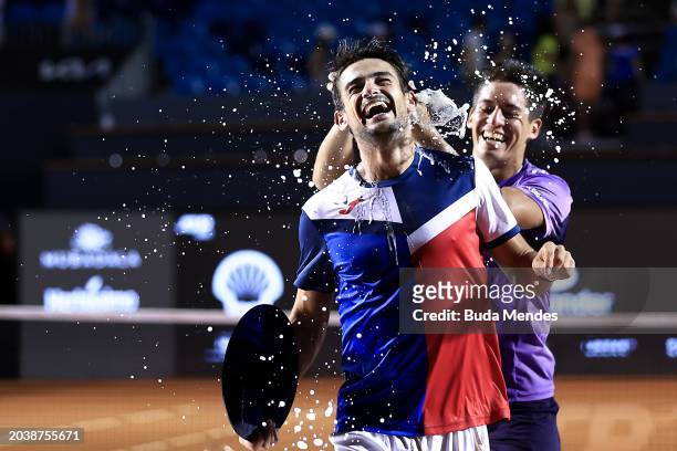 Sebastián Báez of Argentina pours champagne on Mariano Navone of Argentina after winning the final match against of Argentina of ATP 500 Rio Open...