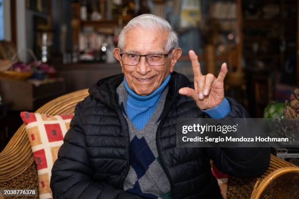 older senior latino man looking at the camera and doing the heavy metal horns hand sign - heavy metal horns stock pictures, royalty-free photos & images