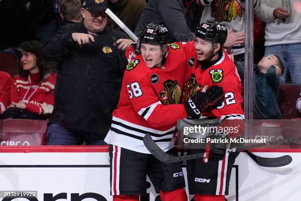 MacKenzie Entwistle of the Chicago Blackhawks celebrates scoring a goal with Reese Johnson in the second period against the Detroit Red Wings at the...