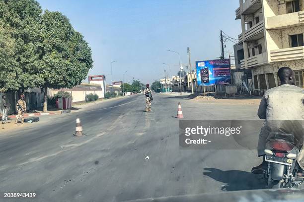 Picture taken throough a car window shows Chadian soldiers barring the entrance to the road leading to the Presidential Palace in N'Djamena on...