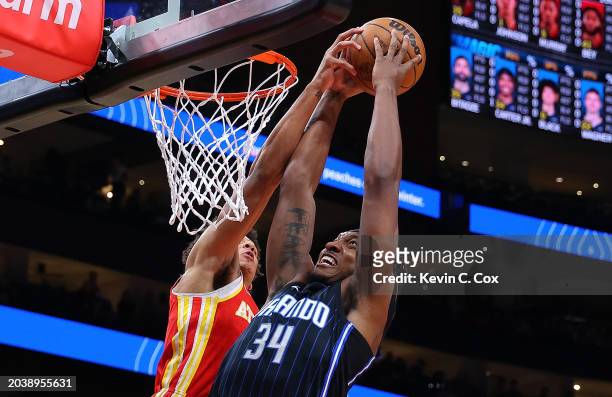Jalen Johnson of the Atlanta Hawks blocks a dunk attempt by Wendell Carter Jr. #34 of the Orlando Magic during the first quarter at State Farm Arena...