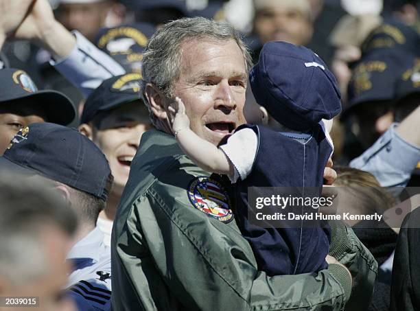 President George W. Bush holds a baby at the Naval Station Mayport February 13, 2003 after his speech to sailors and military personnel in...