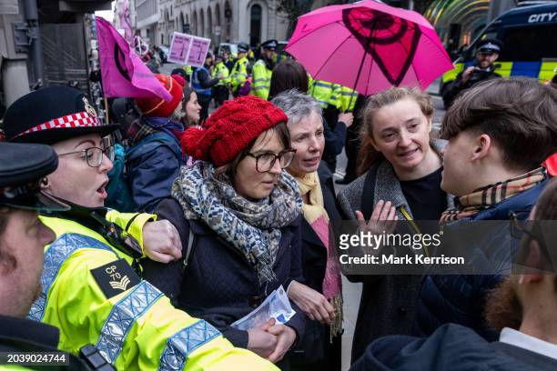 Climate activists from Extinction Rebellion speak to a member of the public seeking to breach their blockade around Lloyds of London in protest...