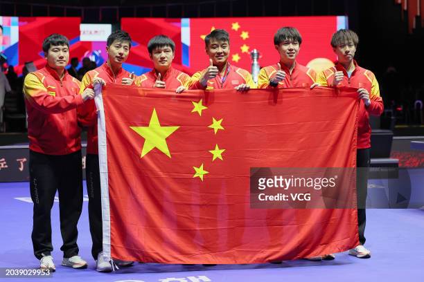 Liang Jingkun, Ma Long, Fan Zhendong, head coach Ma Lin, Wang Chuqin and Lin Gaoyuan pose with Chinese national flag after winning the Final match...