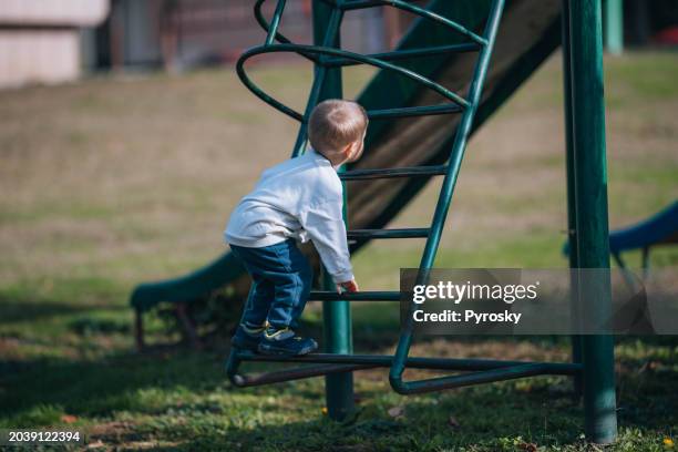 little boy having fun on a playground - climbing frame stock pictures, royalty-free photos & images