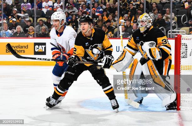 Pierre Engvall of the New York Islanders and Chad Ruhwedel of the Pittsburgh Penguins battle for position at PPG PAINTS Arena on February 20, 2024 in...