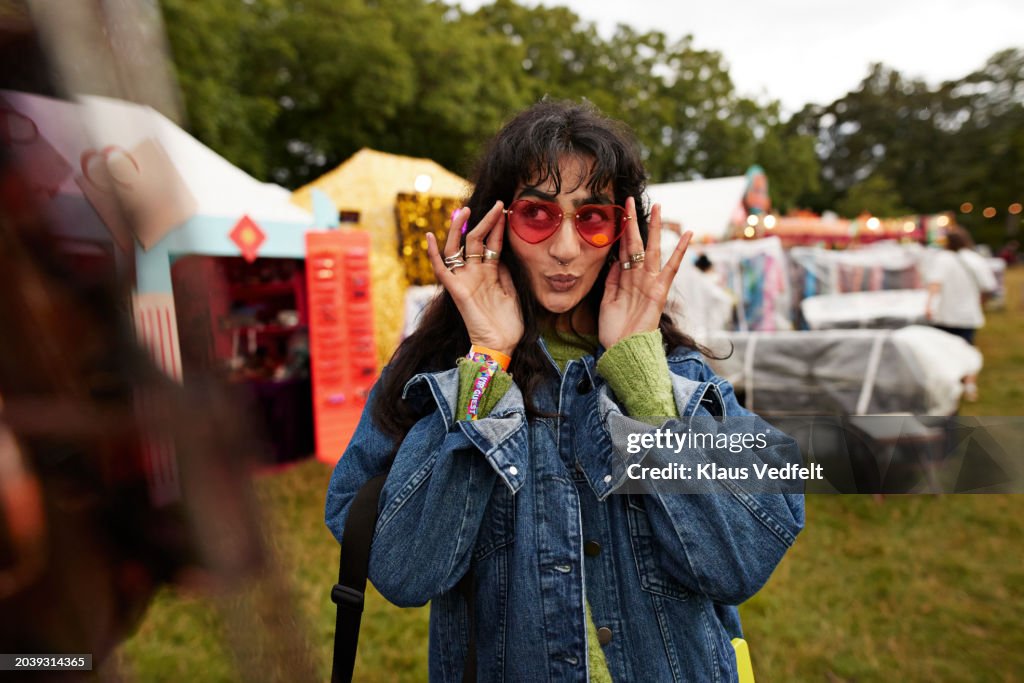 Woman puckering while wearing red sunglasses