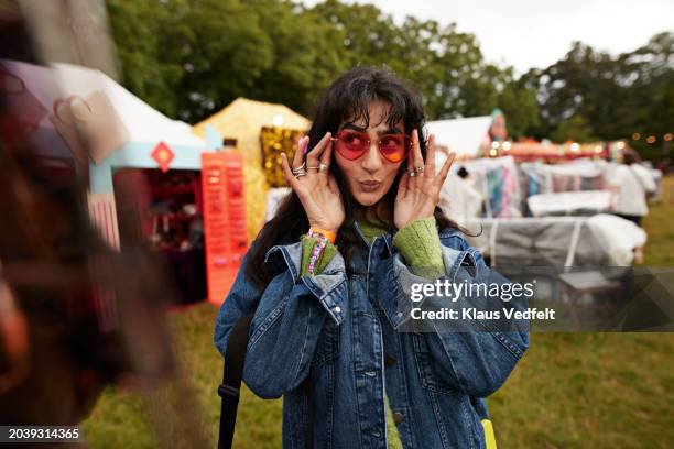 woman puckering while wearing red sunglasses - denim coat stock pictures, royalty-free photos & images