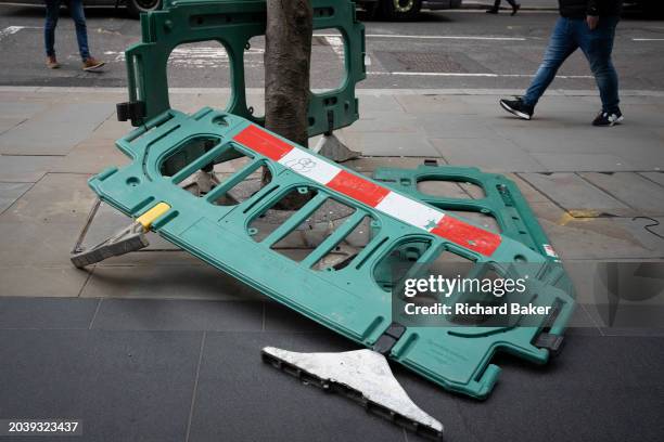 Pedestrians walk around a works barrier that has fallen over on Leadenhall in the City of London, the capital's financial district, on 28th February...