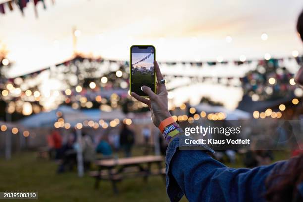 hand of woman photographing bunting through phone - sunset stock pictures, royalty-free photos & images