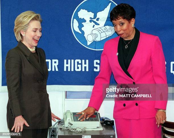 First Lady Hillary Rodham Clinton and principal Rhia Warren react as a public address system beeps uncontrollably following morning announcements...