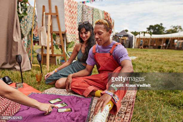couple sitting with fortune teller and tarot cards - design by hand series celebration stock pictures, royalty-free photos & images