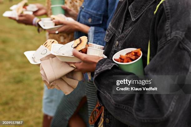 midsection of friends carrying street food - streetfood stock-fotos und bilder