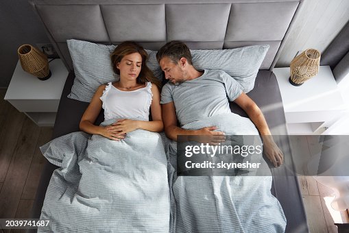 Vista superior de una pareja relajada durmiendo en la cama. Vista superior de una pareja relajada durmiendo en la cama.