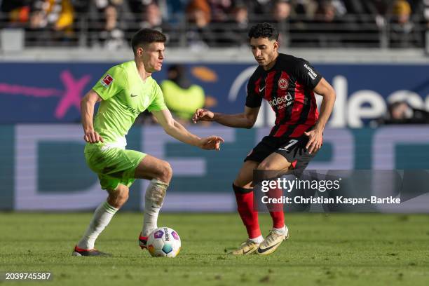 Joakim Maehle of VfL Wolfsburg challenges Omar Marmoush of Eintracht Frankfurt during the Bundesliga match between Eintracht Frankfurt and VfL...