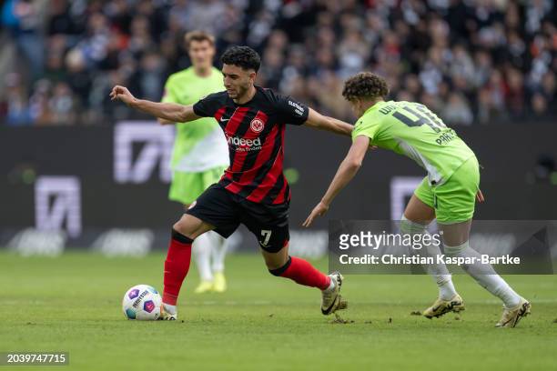 Omar Marmoush of Eintracht Frankfurt is tackled by Kevin Paredes of VfL Wolfsburg during the Bundesliga match between Eintracht Frankfurt and VfL...