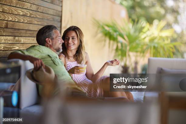 happy couple talking while enjoying in summer day on a patio. - veranda stock pictures, royalty-free photos & images