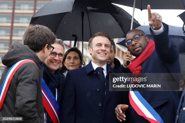 Ile-Saint-Denis' mayor Mohamed Gnabaly speaks with France's President Emmanuel Macron , next to Seine Saint-Denis' Council member Stephane Troussel...