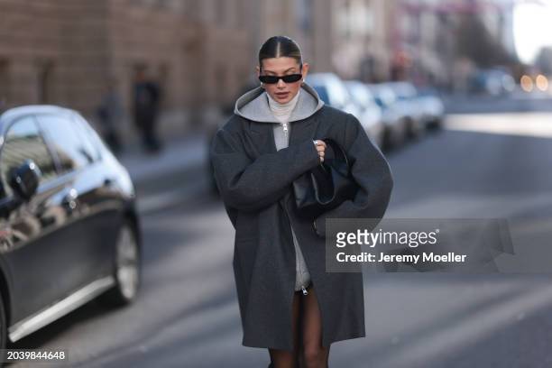 Sophia Geiss seen wearing Saint Laurent black sunglasses, silver earrings, COS dark grey oversized short wool coat, Arket grey cotton hooded zip...
