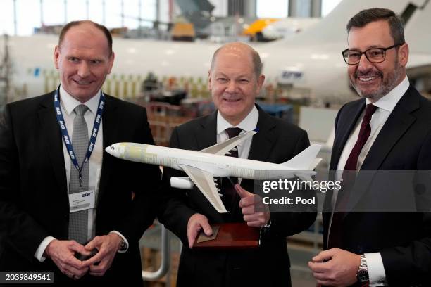 German Chancellor Olaf Scholz receives a model airplane as a gift from EFW CEO Jordi Boto and EFW CFO Kai Mielenz as he tours the EFW Elbe...