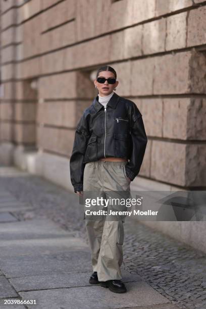 Sophia Geiss seen wearing Prada black Symbole sunglasses, silver earrings, Intimissimi creamy white sheer high neck top, LeGer black leather collar...