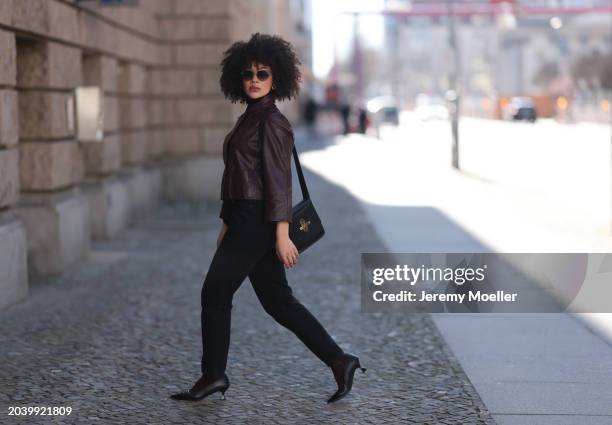 Julia Dalia seen wearing Tiffany & Co silver sunglasses, gold earrings, Arket black wool knit high neck sweater, burgundy red leather cropped jacket,...