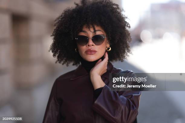 Julia Dalia seen wearing Tiffany & Co silver sunglasses, gold earrings, Arket black wool knit high neck sweater, burgundy red leather cropped jacket,...