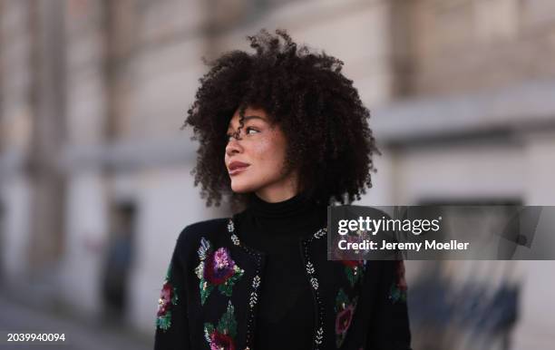 Julia Dalia seen wearing gold earrings, Arket black wool knit high neck sweater, black wool knit colorful flower embroidered cardigan, on February...