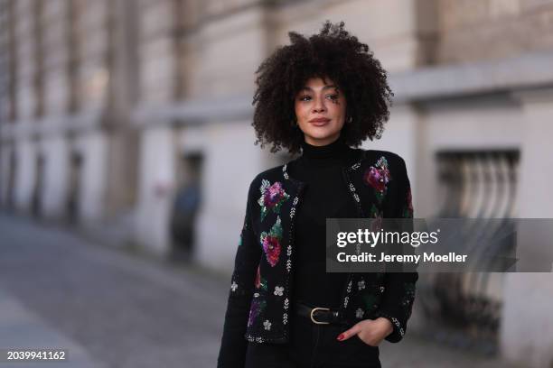 Julia Dalia seen wearing gold earrings, Arket black wool knit turtleneck sweater, black wool knit colorful flower embroidered cardigan, Levi’s black...