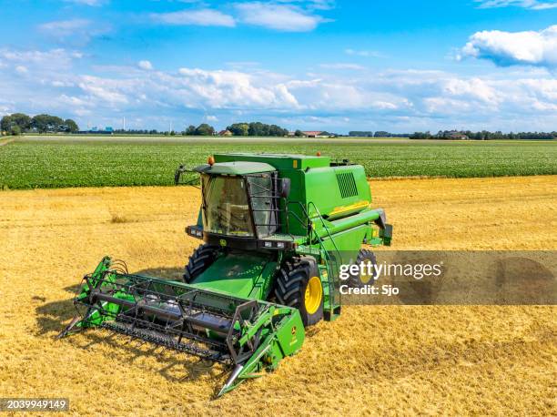 john deere mähdrescher bei der weizenernte im sommer von oben gesehen - landwirtschaftliche maschine stock-fotos und bilder