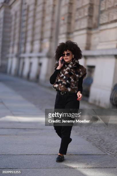 Julia Dalia seen wearing Tiffany & Co silver sunglasses, gold earrings, Arket black wool knit turtleneck sweater, brown / black / white fake fur...