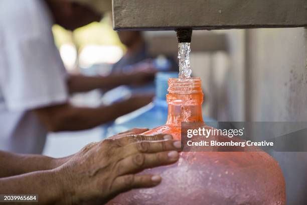 a person filling a water bottle - nuevo leon state stock pictures, royalty-free photos & images