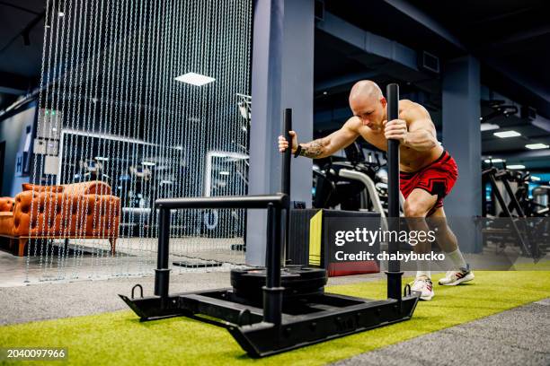 muscular man pushing weights in the gym. exercise - sport determination stock pictures, royalty-free photos & images