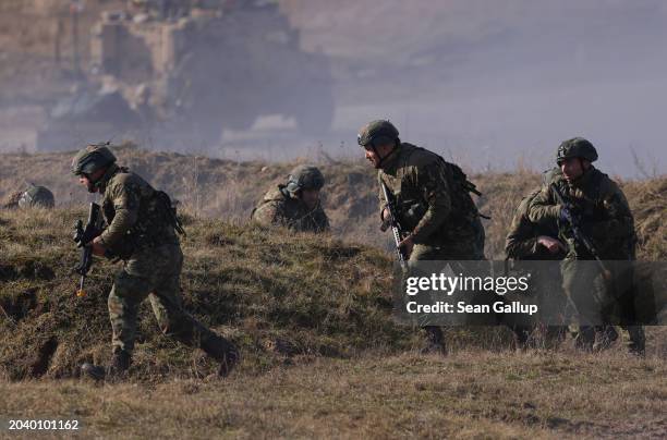 Soldiers of the United Kingdom's 2nd Battalion Royal Anglian infantry unit storm an enemy position in a simulated attack during the NATO "Brilliant...