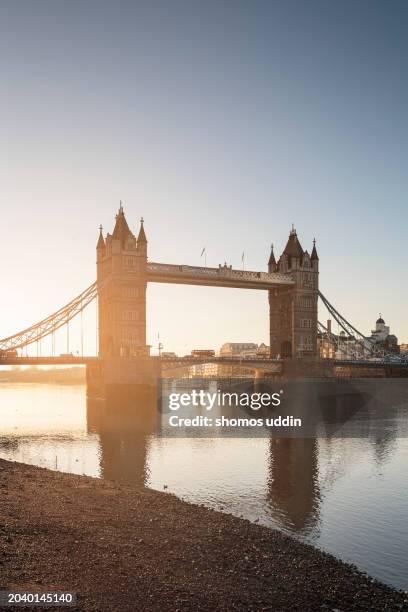 tower bridge and the thames at sunrise - ebbe stock-fotos und bilder