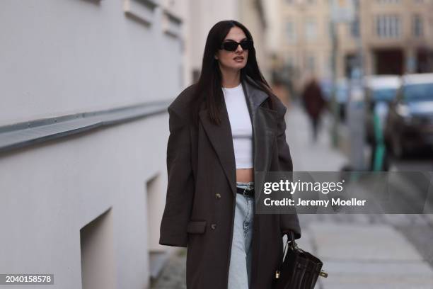 Anna Winter seen wearing Prada black Symbole sunglasses, Edited white cotton basic cropped shirt, The Mannei brown oversized wool long coat with...