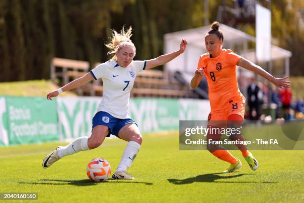 Katie Robinson of England runs with the ball under pressure from Rosa Van Gool of the Netherlands during the International Women's Friendly between...