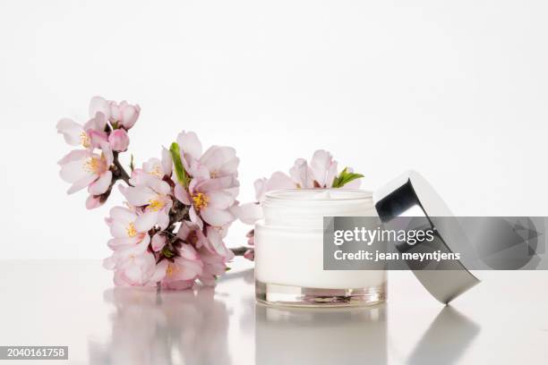 cosmetic: skin cream and almond blossom on white background. - schoonheidsspecialist natuur stockfoto's en -beelden