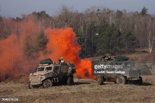 Soldiers of the United Kingdom's 2nd Battalion Royal Anglian infantry unit with OcelotFoxhound vehicles storm an enemy position in a simulated attack...